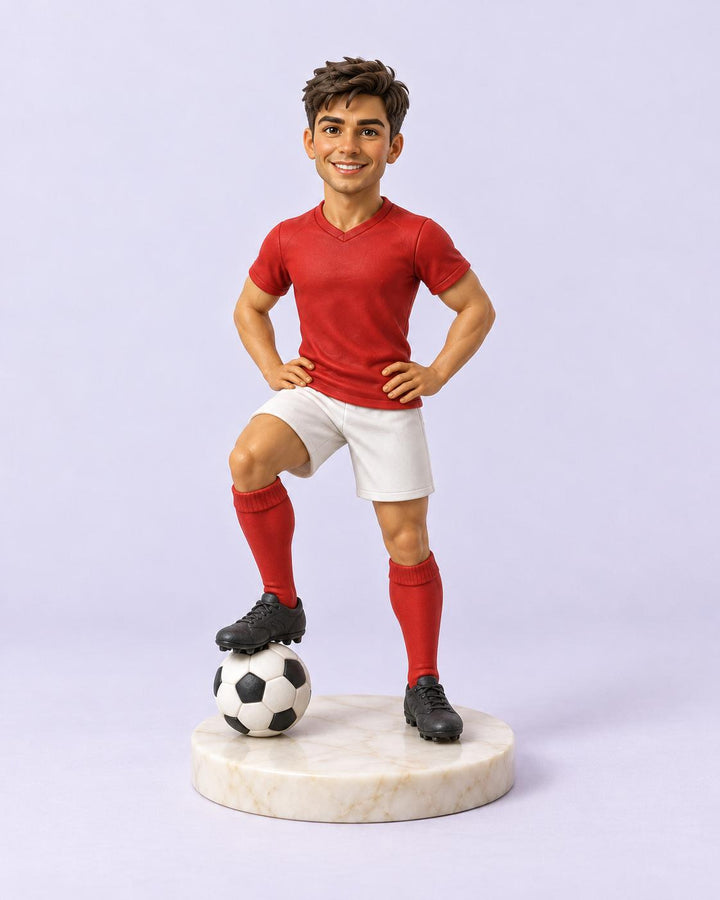 Sculpted football player figurine in a red kit with a ball